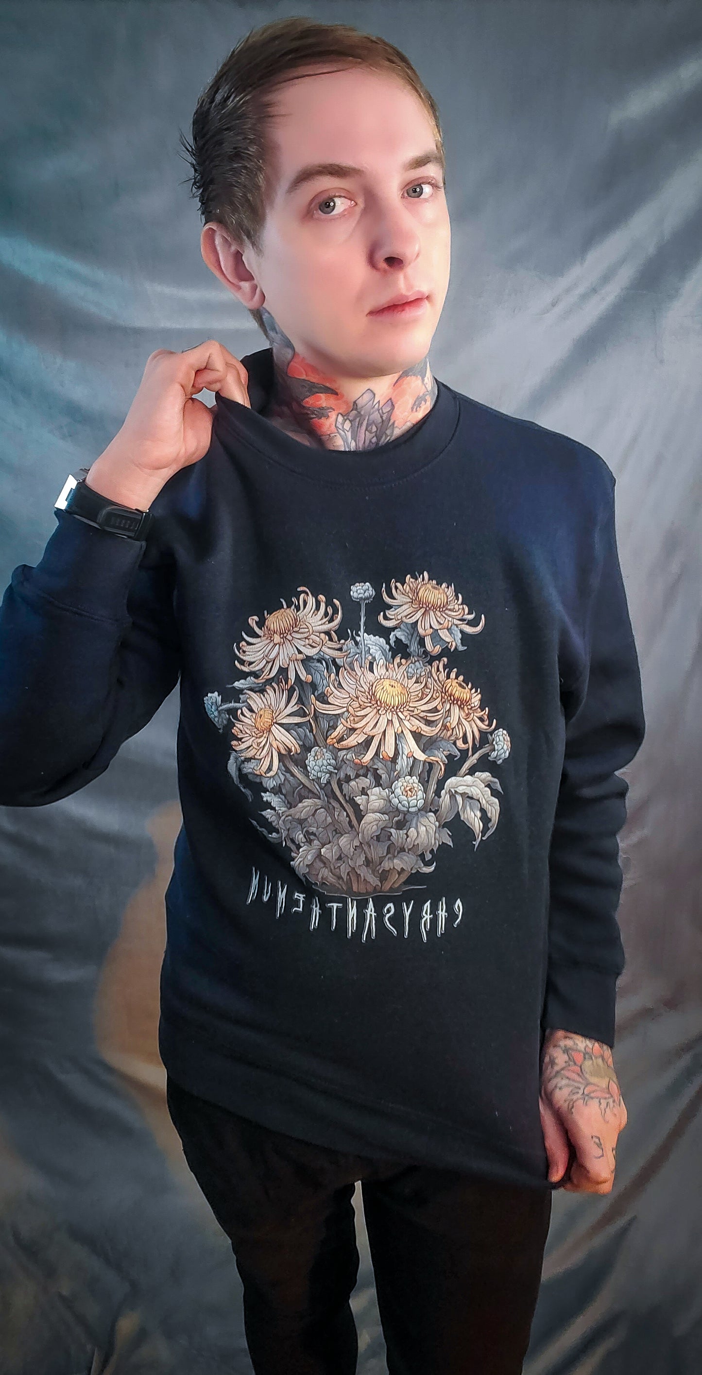 Person models a navy sweatshirt adorned with a detailed chrysanthemum bouquet graphic, with the word 'Chrysanthemum' below