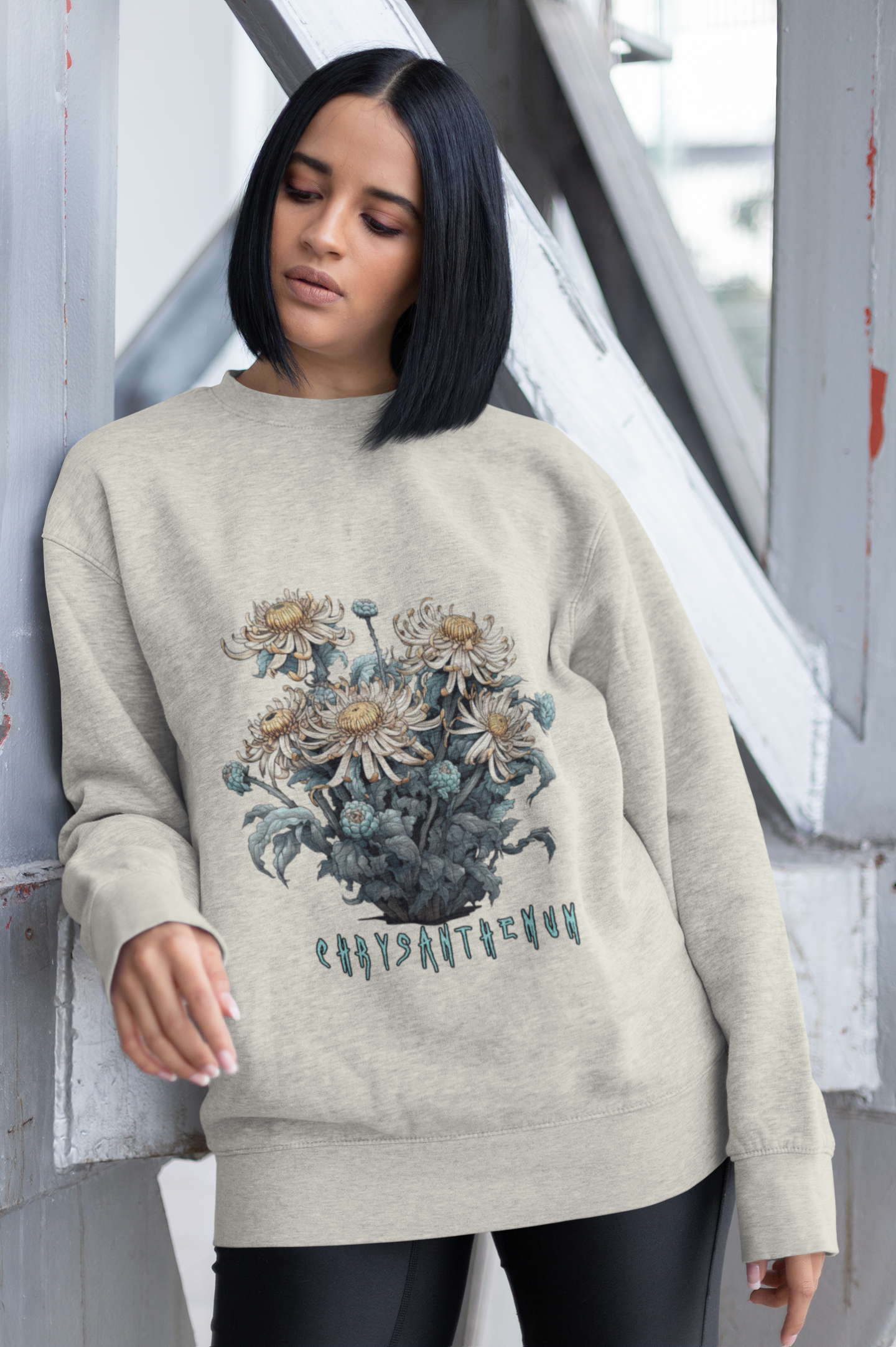 Heather grey sweatshirt adorned with a detailed chrysanthemum illustration and cursive lettering, worn by a woman with dark hair.