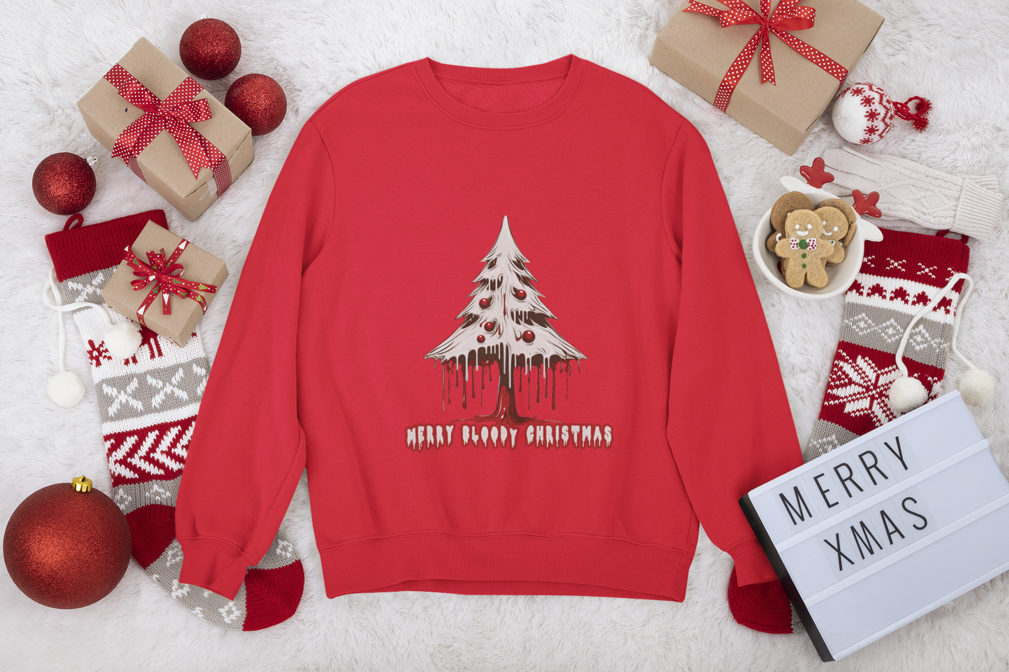 Red sweatshirt with "Merry Bloody Christmas" tree graphic, Christmas gifts, and cozy holiday accessories around.