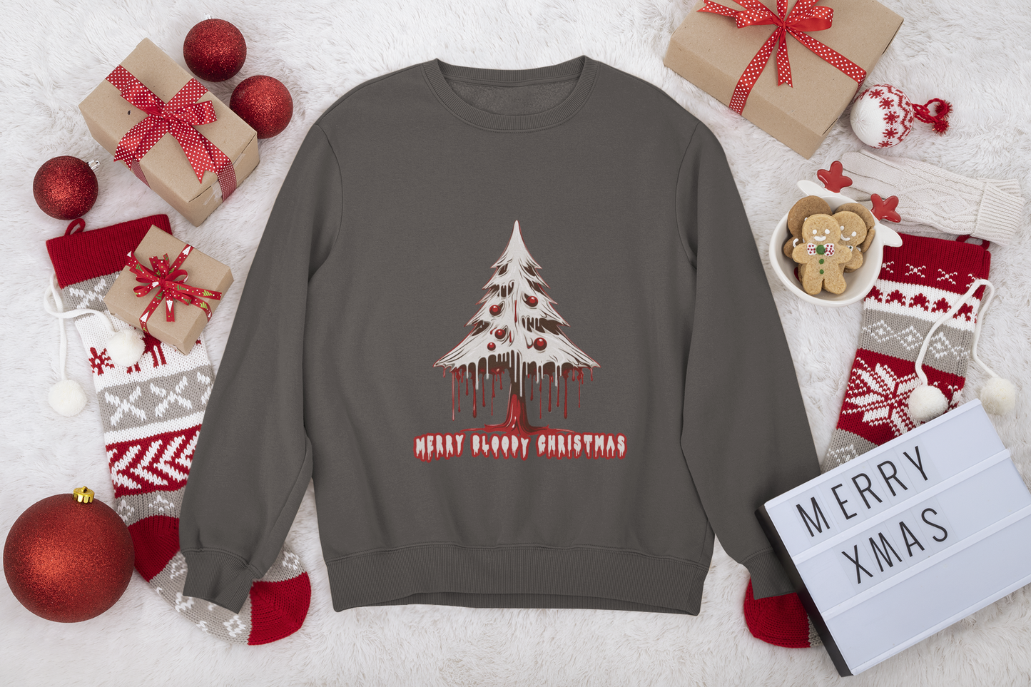 Dark taupe sweatshirt with a festive "Merry Bloody Christmas" tree graphic, set amongst Christmas gifts and decor.