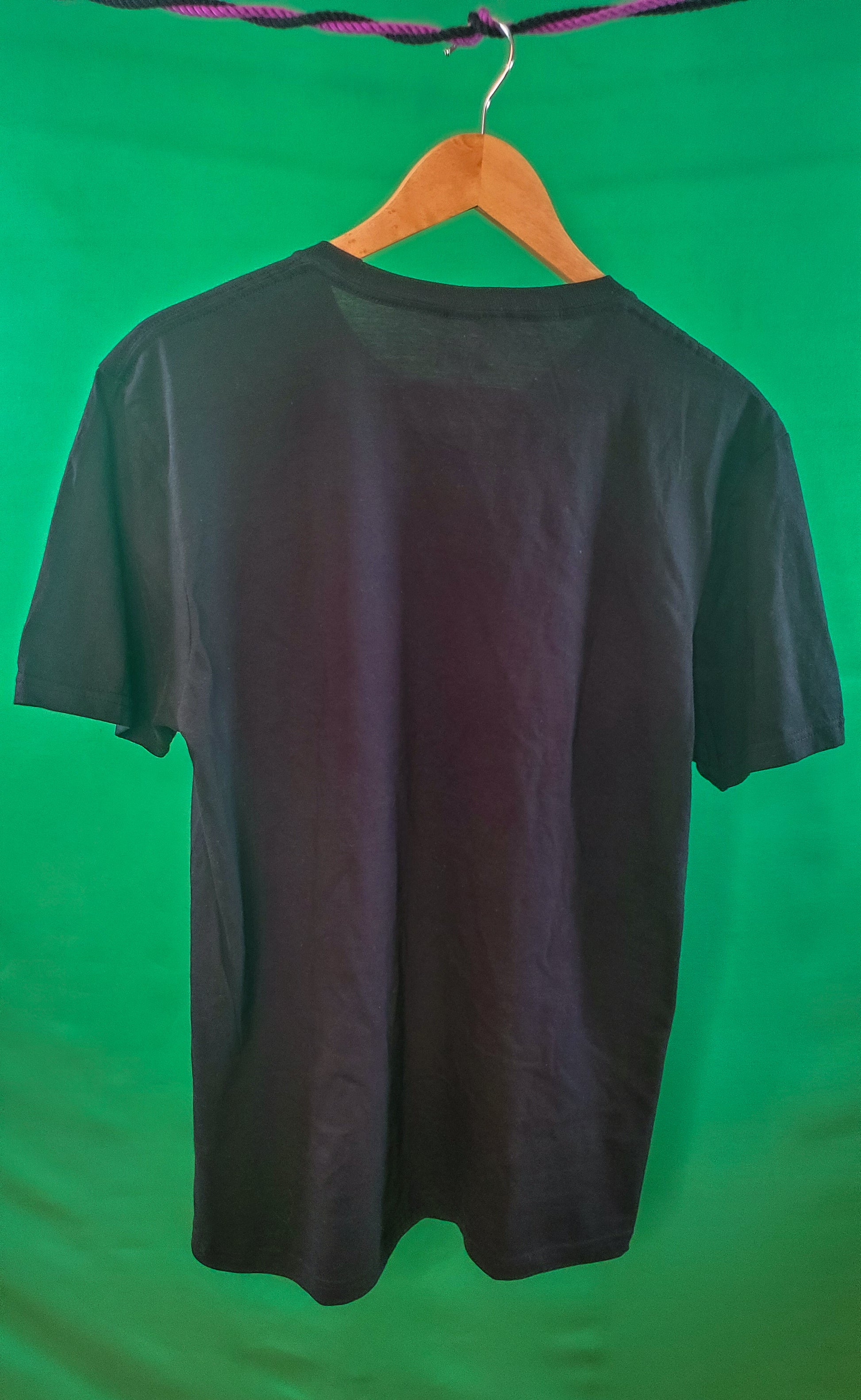 Back view of a plain black T-shirt on a hanger against a green screen