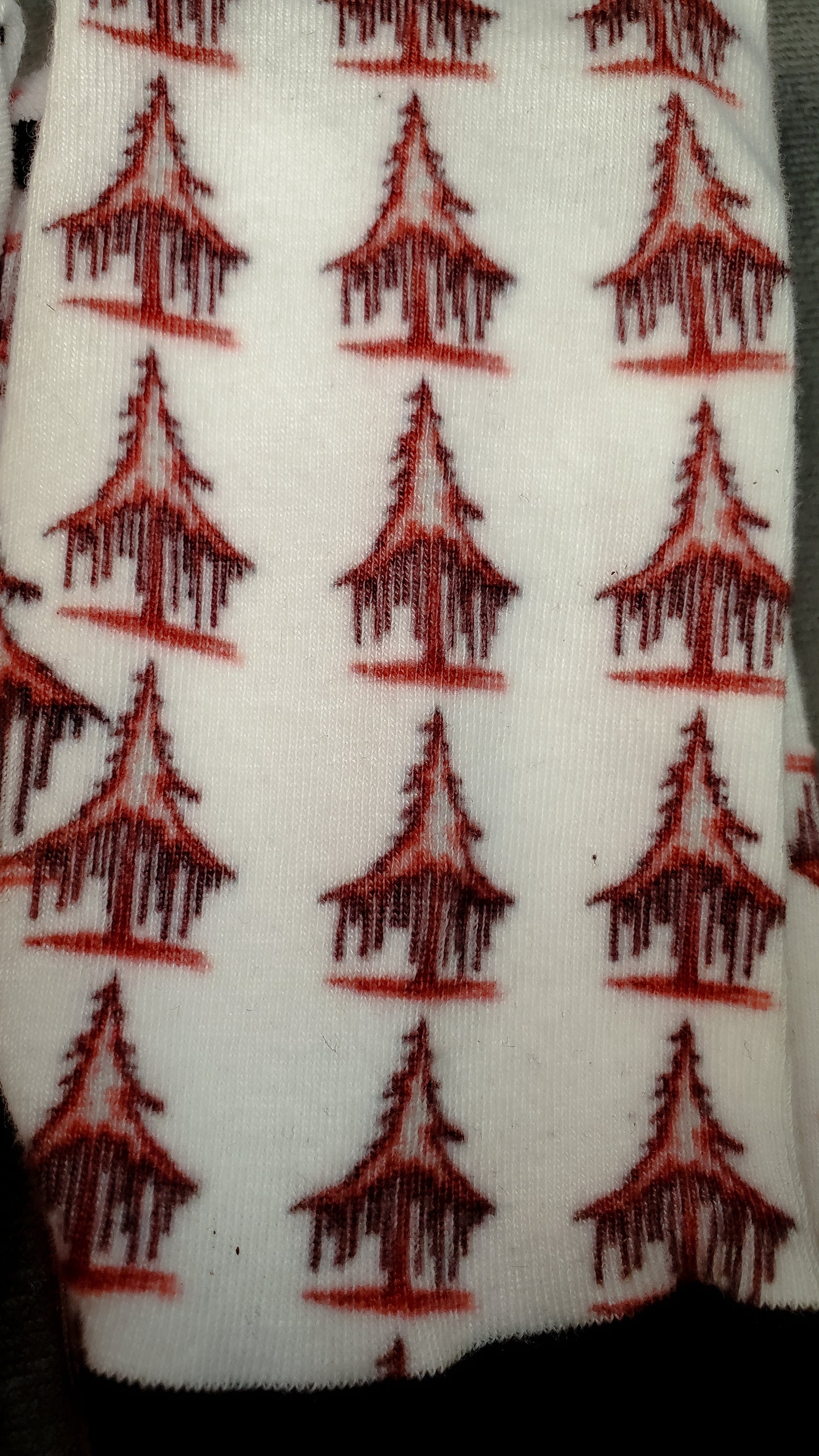 Detail of white socks showcasing a macabre pattern of bleeding solstice trees in red