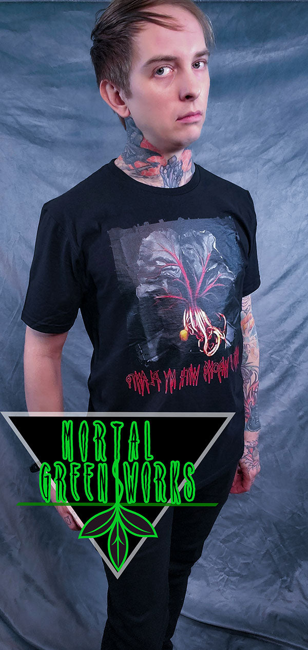 Man posing in a black T-shirt with a haunting fiddle leaf fig design and stylized red text below.