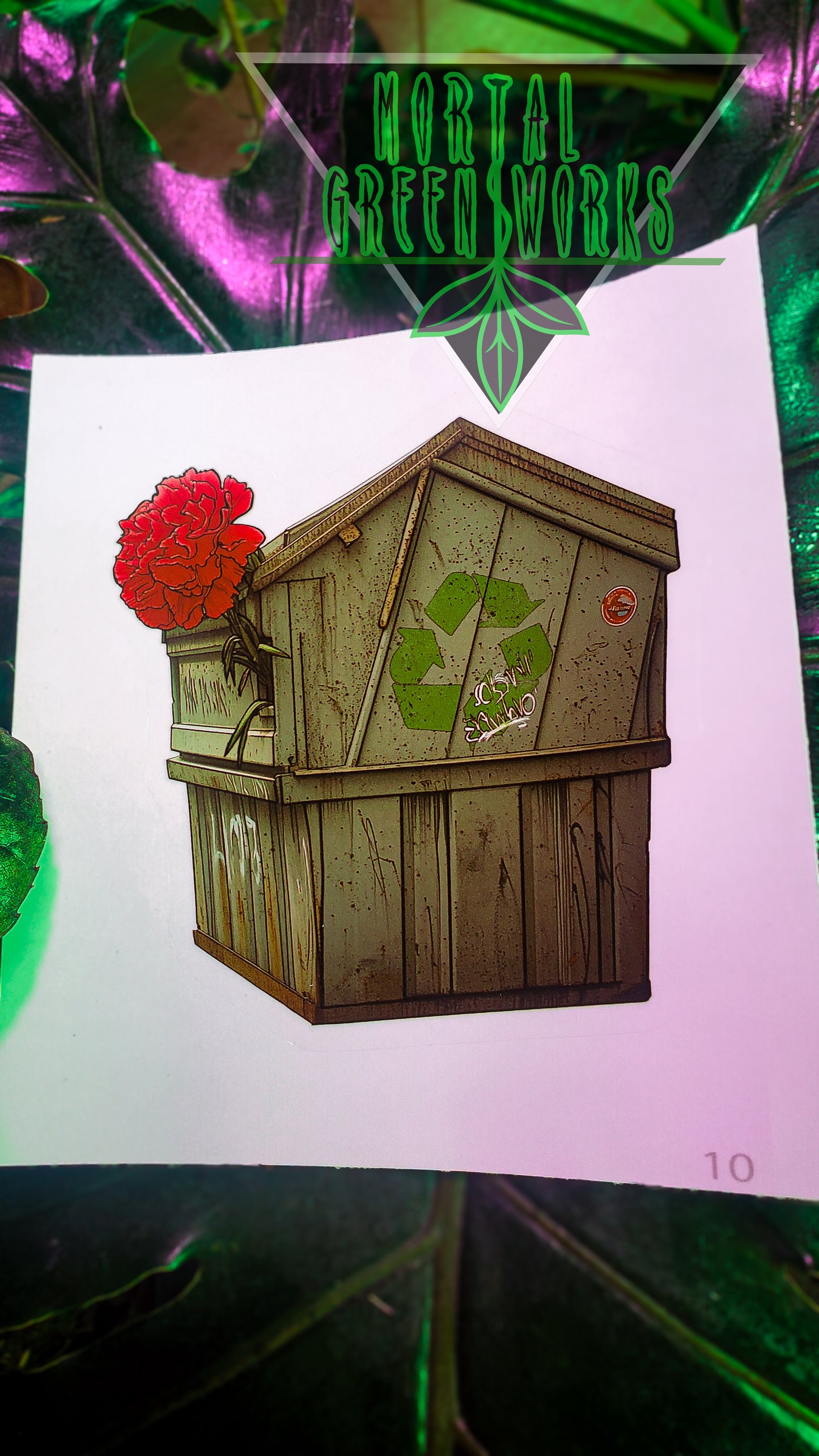 A sticker illustrating a  green recycle bin with a blossoming red carnation, set against a green leafy backdrop with 'Mortal Greenworks' branding.