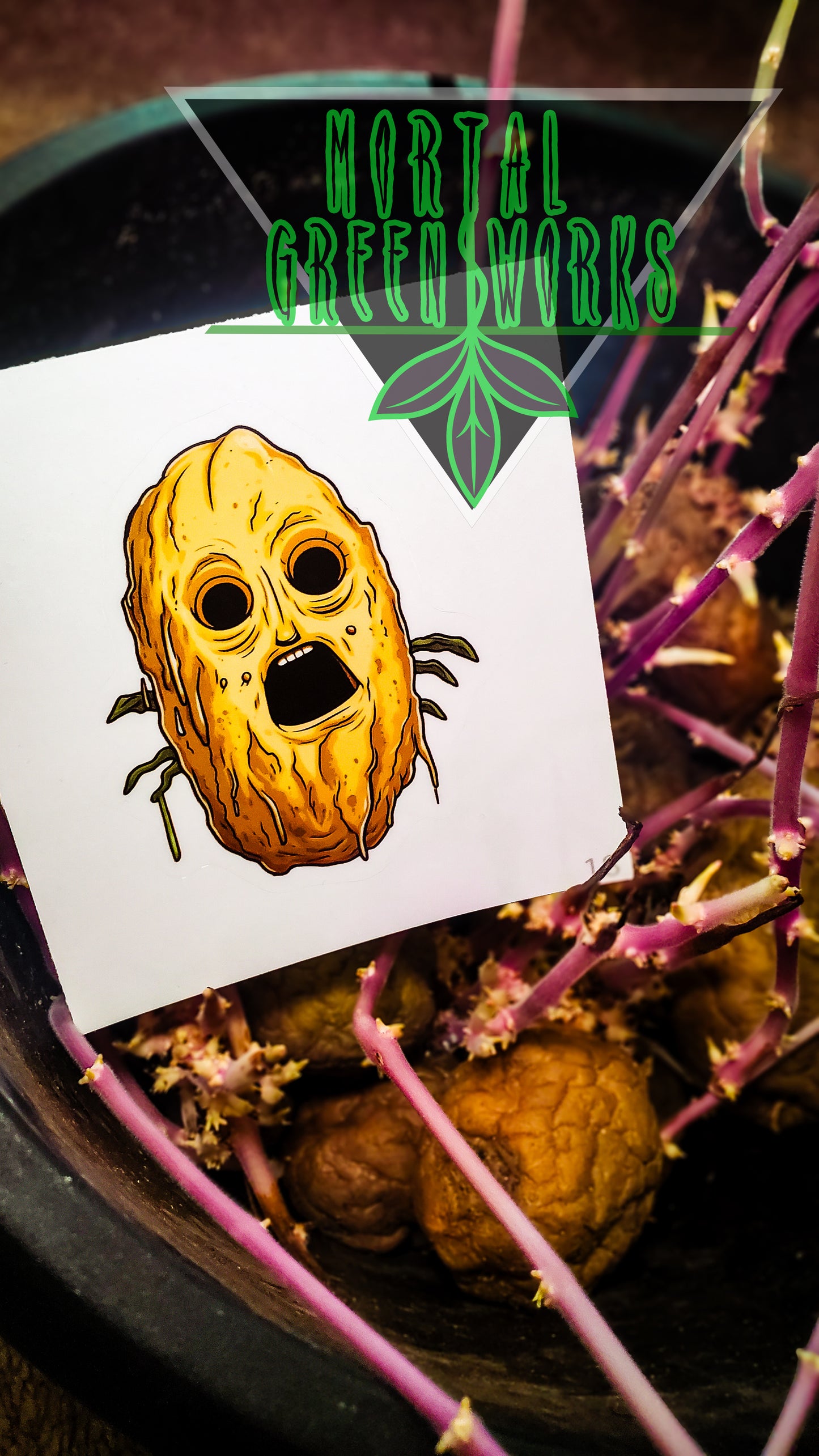 Sticker of a spooky-faced potato atop growing potatoes in a pot, contrasted by vibrant green 'Mortal Greenworks' logo.