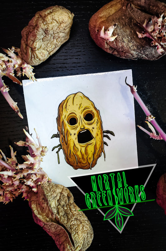 A horror-themed potato face sticker resting among sprouting tubers, accompanied by 'Mortal Greenworks' branding.