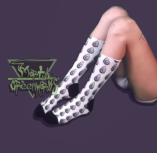 White socks with black pattern worn by a person on a dark purple background, with a logo in the corner.