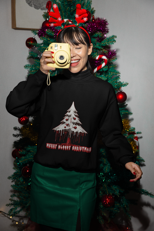Woman with reindeer antlers headband taking a photo, wearing a black sweatshirt with a "Merry Bloody Christmas" tree design.